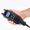 A hand holding a black CB radio. Voir les images du produit