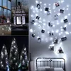 A collage of decorative lighting items, including a lantern, string lights with photos, and small Christmas trees. Voir les images du produit