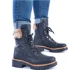 A pair of black Rieker women's lace-up boots with faux fur trim, worn with cuffed blue jeans. Anteprima dell’immagine prodotto