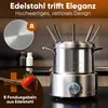 A stainless steel electric fondue set is displayed on a dark countertop, with a strawberry dipped in chocolate on a fondue fork in the foreground. Voir les images du produit