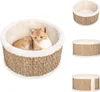 A cat is resting in a round cat bed. The bed is made of woven seagrass with a soft, cream-colored lining. The image also shows two additional views of the empty cat bed. Náhled obrázku produktu