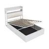A white metal bed frame with a slatted base lifted to reveal storage space underneath. The headboard has shelves and a padded section. Produktbild-Vorschau