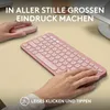 A person's hands are shown using a pink Logitech Pebble 2 combo, consisting of a wireless keyboard and mouse, on a desk. Produktbild-Vorschau