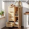 A wooden cabinet with open doors and drawers, showcasing storage options. Bread and plates are on top. Náhled obrázku produktu