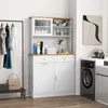 A white storage cabinet with a wood-tone countertop and top, shown in a laundry room setting next to a washing machine and a clothing rack. Podgląd zdjęcia produktu