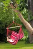 A woman relaxing in a hammock chair hanging from a tree in a garden. Náhled obrázku produktu