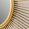 A close-up shot of a gold sunburst mirror frame against a textured gray background. Produktbild-Vorschau
