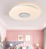 A bedroom with pink walls, a decorative headboard, and a modern ceiling light. Produktbild-Vorschau