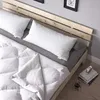 A close-up view of a bed with white pillows and a white duvet. Náhled obrázku produktu