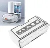 A robot vacuum cleaner and its dust collection bin are displayed against a light gray and white background. The dust bin is shown in the foreground with instructional graphics on its surface. Produktbild-Vorschau