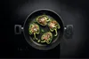 Stuffed bell peppers cooking in a pan on a stovetop. Produktbild-Vorschau
