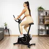 A woman is exercising on a stationary bike in a home gym setting. Náhľad obrázku produktu
