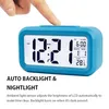 A finger pressing the top of a blue digital alarm clock, showing the time, date, and temperature. Náhled obrázku produktu