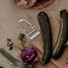 A kitchen counter with vegetables and a peeler. Produktbild-Vorschau