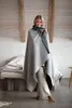 A woman wrapped in a blanket in a bedroom setting. Produktbild-Vorschau