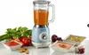 A vintage-style blender is shown on a white surface with fresh vegetables and bowls of soup. Produktbild-Vorschau