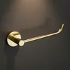 A gold toilet paper holder mounted on a dark gray wall. Produktbild-Vorschau
