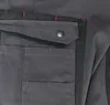 A close-up view of a dark gray work pant pocket. Produktbild-Vorschau