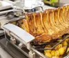 A roasted rack of ribs and potatoes in a roasting pan on a stovetop. Produktbild-Vorschau