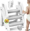 A baby reaching for a white step stool. Produktbild-Vorschau