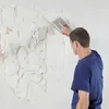 A man is plastering a wall with a trowel. Produktbild-Vorschau