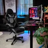 A gaming chair and desk setup in a room with ambient lighting. Produktbild-Vorschau