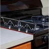 A black stove gap cover is shown installed on a gas stove, with arrows indicating how it prevents items from falling into the gap between the stove and the countertop. Anteprima dell’immagine prodotto