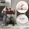 A woman is shown attaching a bassinet to a stroller outdoors. Voir les images du produit