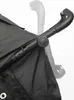 Close-up of a black stroller handle and fabric. Voir les images du produit