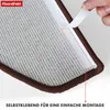 A close-up of the underside of a carpet stair tread, showing the self-adhesive backing being peeled off. Produktbild-Vorschau