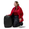 Frau in roter Jacke und schwarzen Hardshellhosen von Berghaus; kniend neben einem kompakten; schwarzen Packbeutel. Anteprima dell’immagine prodotto
