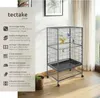 A bird cage with several birds inside, placed on a wooden floor next to a window with curtains. The left side of the image shows a list of product features with icons. Náhled obrázku produktu