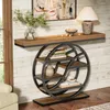 A console table with a geometric metal frame and wooden shelves is placed against a wood-paneled wall, next to a window and a sofa. Decorative items like books, a vase with greenery, a lamp, and bowls are arranged on the table and shelves. Anteprima dell’immagine prodotto
