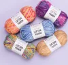 Several balls of yarn are arranged on a light purple background. Produktbild-Vorschau