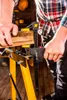 A person is using a clamp to hold pieces of wood together on a workbench. Produktbild-Vorschau