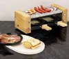 A raclette grill with food items on a marble countertop. Produktbild-Vorschau