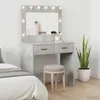 A vanity table with a lighted mirror, a stool, and a snake plant in a pot, next to a bed. Náhľad obrázku produktu