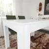 A white dining table with green chairs in a well-lit room. Produktbild-Vorschau