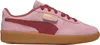 A side view of a pink Puma sneaker with red accents and a gum sole. Produktbild-Vorschau