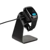 A smartwatch is placed on a black charging stand, connected by a USB-C cable. Produktbild-Vorschau