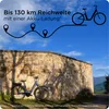 An electric bicycle is parked next to a stone wall with shadows cast by trees. Produktbild-Vorschau