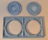 Two circular stove top rings and a rectangular stove top frame are laid out on a brown surface. Náhľad obrázku produktu