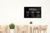 A cafe interior with a menu board on the wall and tables and chairs. Produktbild-Vorschau