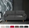 A dark gray sofa is displayed in a modern living room setting with abstract art and patterned wallpaper. Voir les images du produit