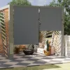 An outdoor patio area with a pergola, furniture, and a fire pit, featuring two gray roller shades. Voir les images du produit