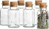 A set of six glass jars with cork stoppers, one of which is filled with dried herbs. Produktbild-Vorschau