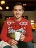 A man wearing a Christmas sweater with The Grinch on it, holding a white mug. Náhľad obrázku produktu