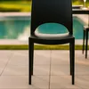 A black chair is placed on a tiled patio next to a swimming pool. Voir les images du produit