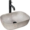 A beige oval countertop sink with a black faucet. Anteprima dell’immagine prodotto