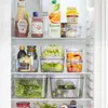 A well-organized refrigerator shelf filled with various food items and storage containers. Produktbild-Vorschau